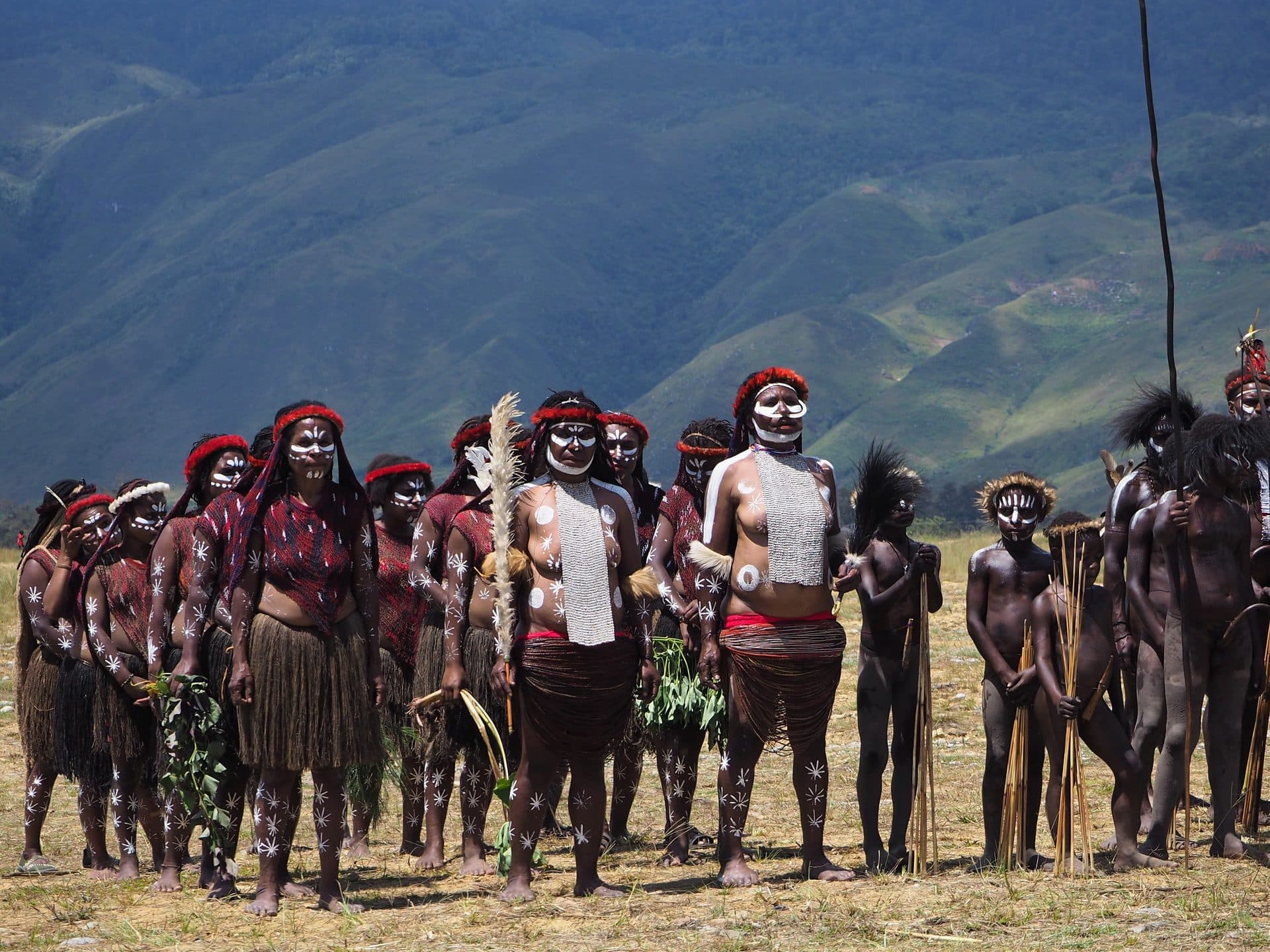 Warriors in body paint and feather headdresses line up at the opening ceremony of the Baliem Valley Festival in Papua