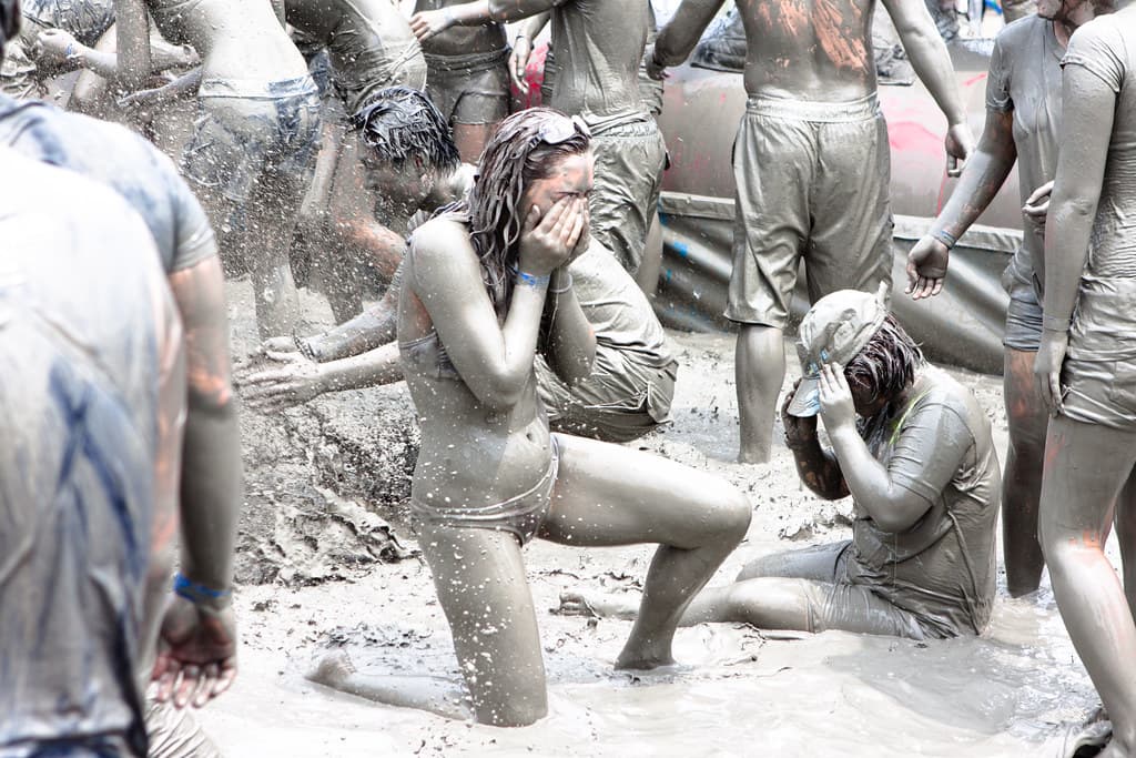 Festival-goers covered in grey mud at the Boryeong Mud Festival