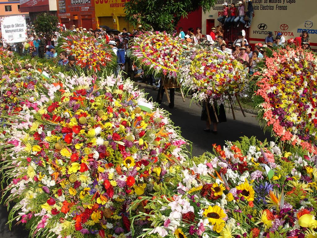 Dozens of large round silletas packed with colourful flowers fill the street during the Desfile de Silleteros in Medellín