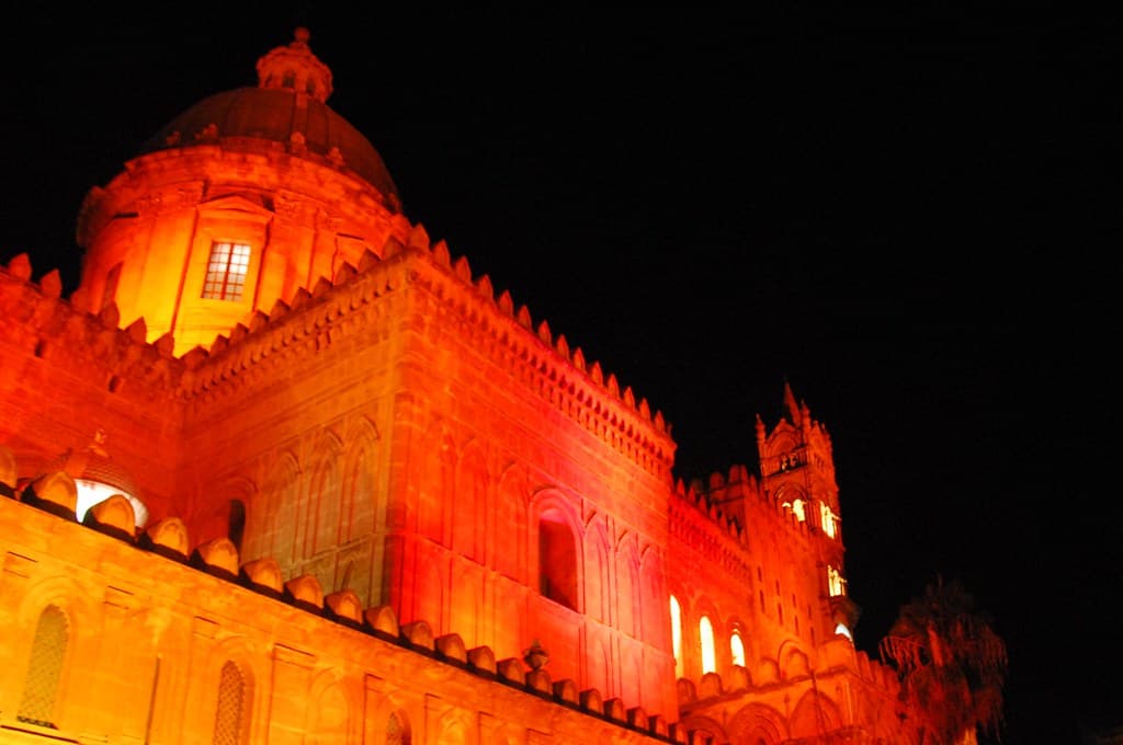 Palermo Cathedral glows red and orange under festival lights on the night of the Festino di Santa Rosalia