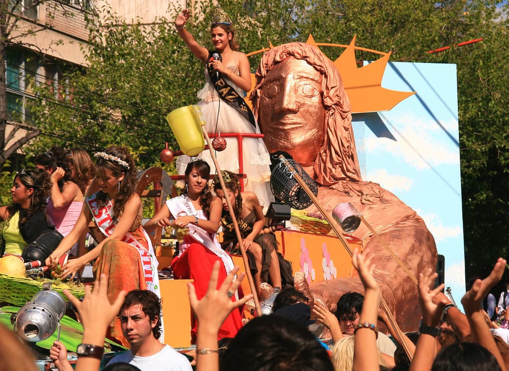 A harvest queen waves from a parade float decorated with a giant figure during the Vendimia Carrusel in Mendoza