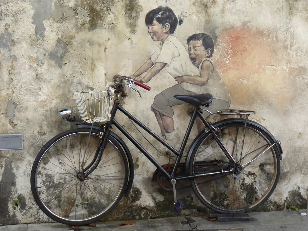 A street mural of two children on a bicycle in George Town, Penang