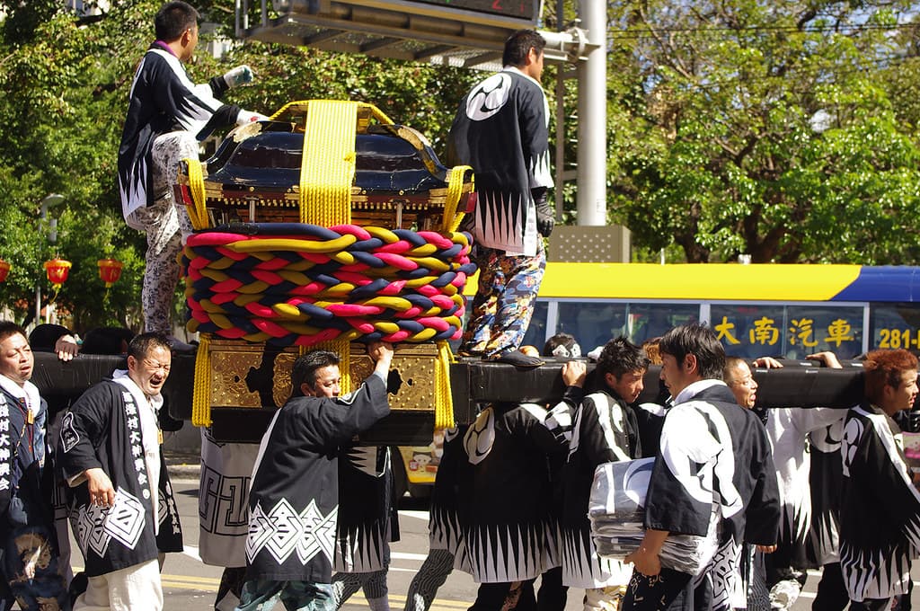 Bearers in happi coats carrying a portable shrine through the streets at Kanda Matsuri