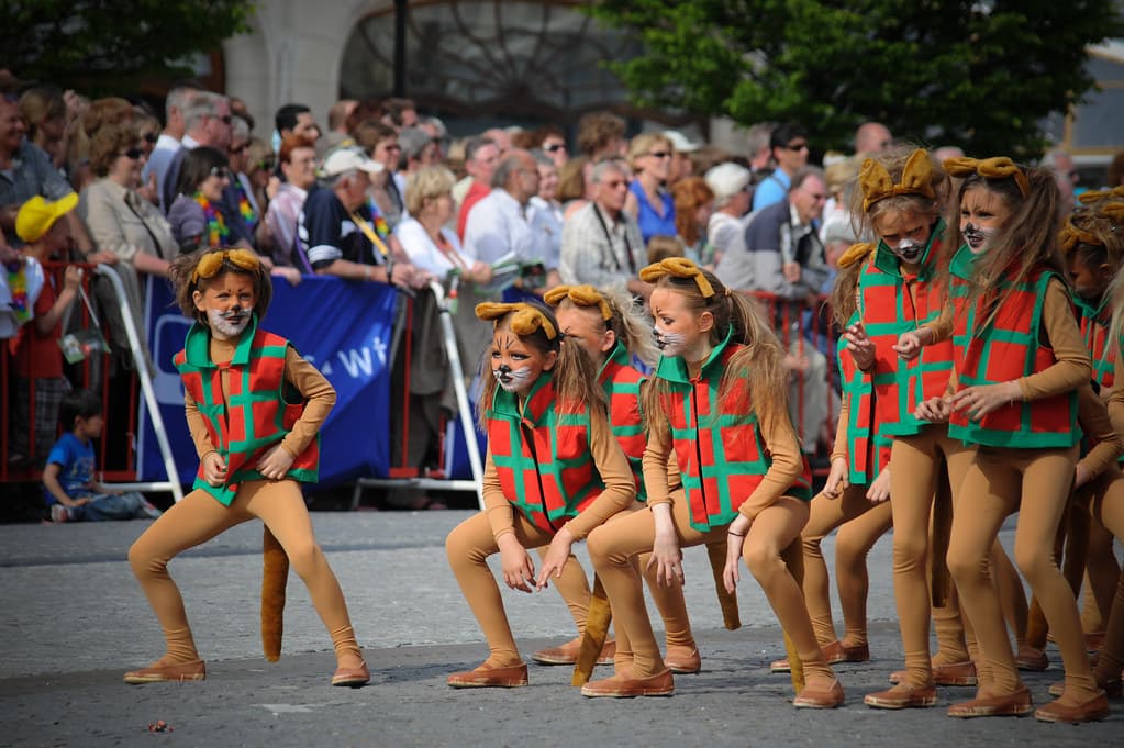 Dancers dressed as cats perform in the street in front of crowds during the Kattenstoet cat parade in Ypres