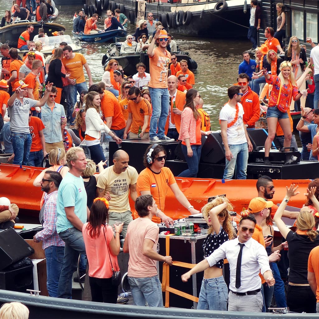 A boat full of people in orange celebrating King's Day on the Amsterdam canals