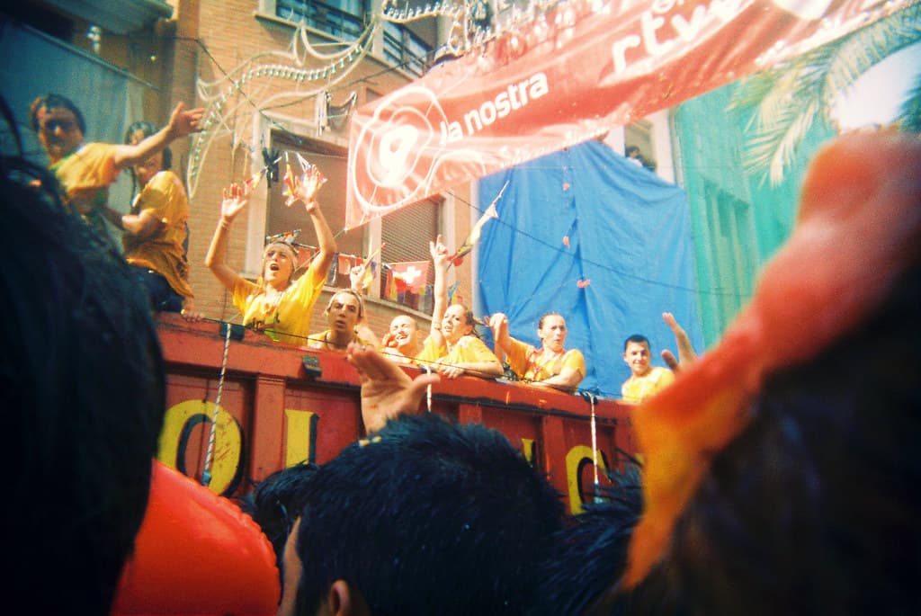 Crew on a truck pelt the crowd with tomatoes in a narrow Buñol street during La Tomatina