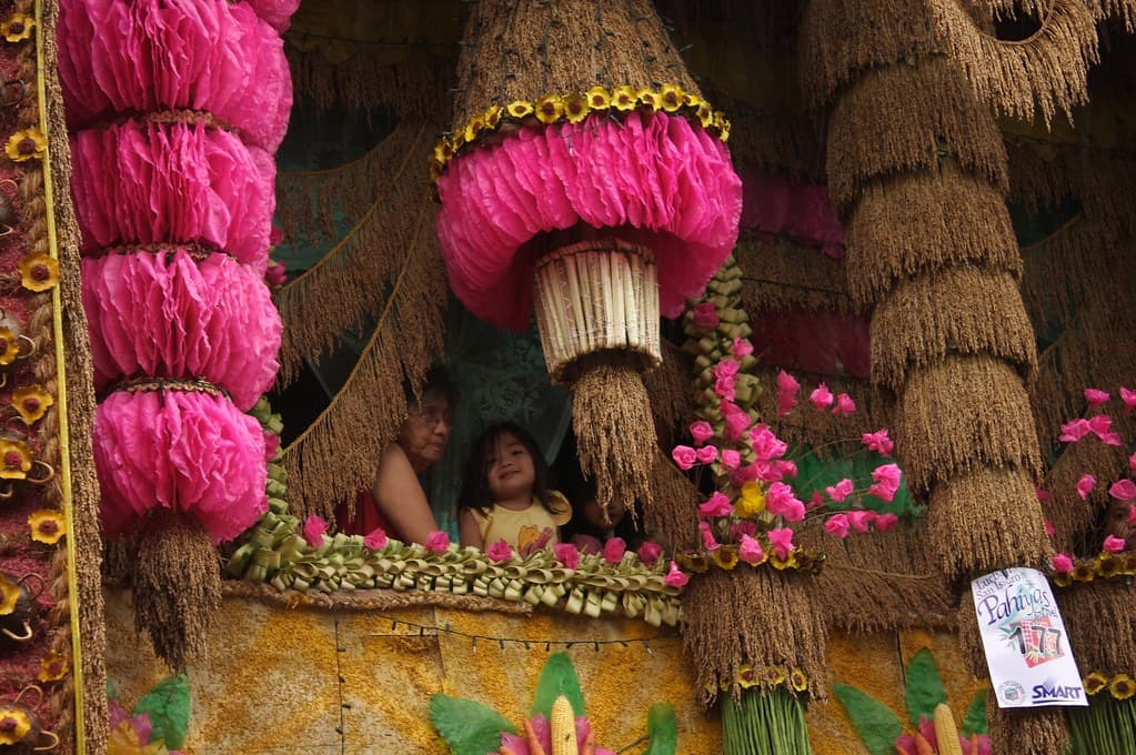 A house in Lucban decorated with pink and yellow kiping rice wafers, rice stalks and produce for the Pahiyas Festival