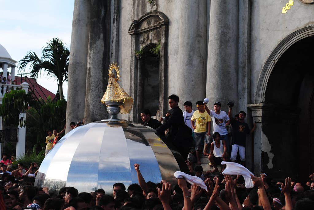 Devotees in Naga City wave white handkerchiefs as the image of Our Lady of Peñafrancia is carried on a silver andas