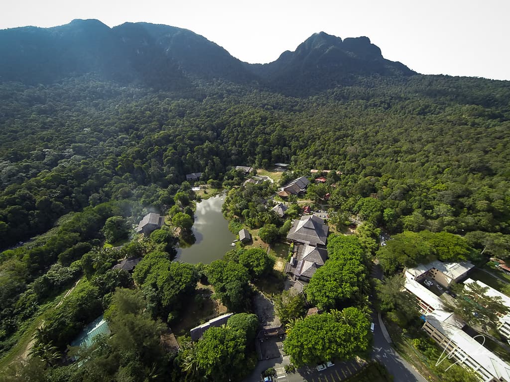 Aerial view of the Sarawak Cultural Village, its traditional houses around a lake in the forest below Mount Santubong