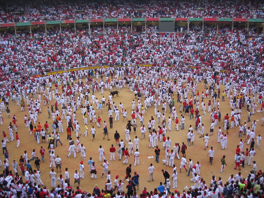 Pamplona's bullring packed with runners and spectators dressed in white with red neckerchiefs during San Fermín