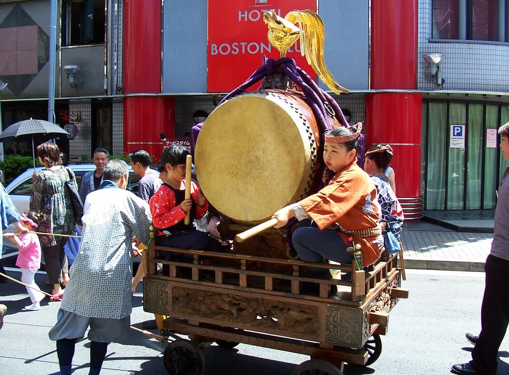 A drummer riding a festival cart through the streets of Asakusa during Sanja Matsuri