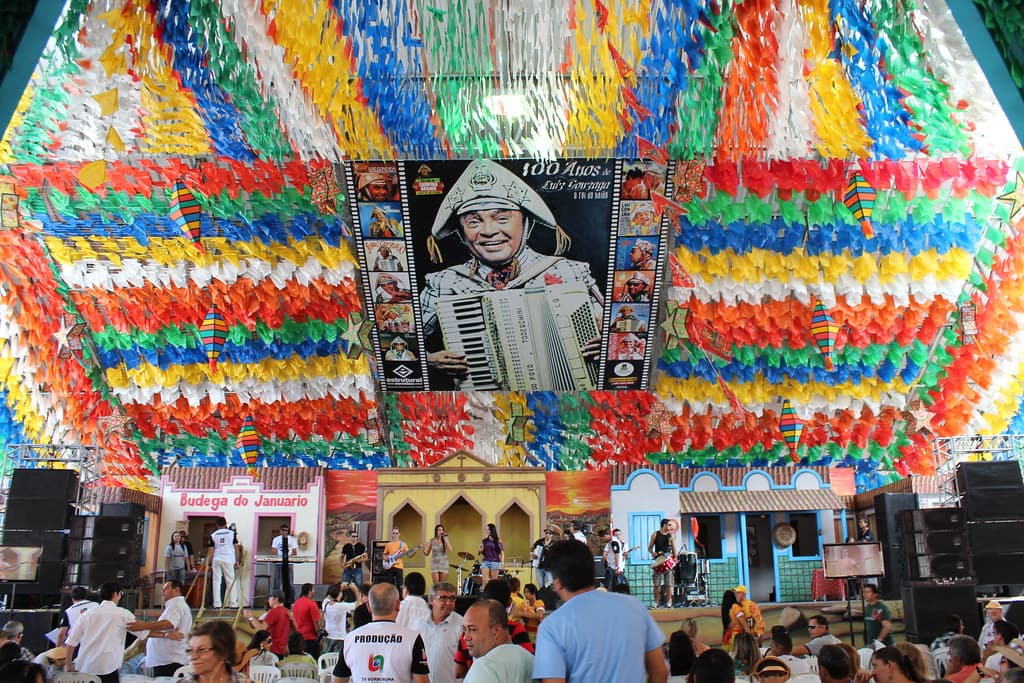 Thousands of strings of coloured paper bunting hang over a stage and crowd at the São João festival in Campina Grande