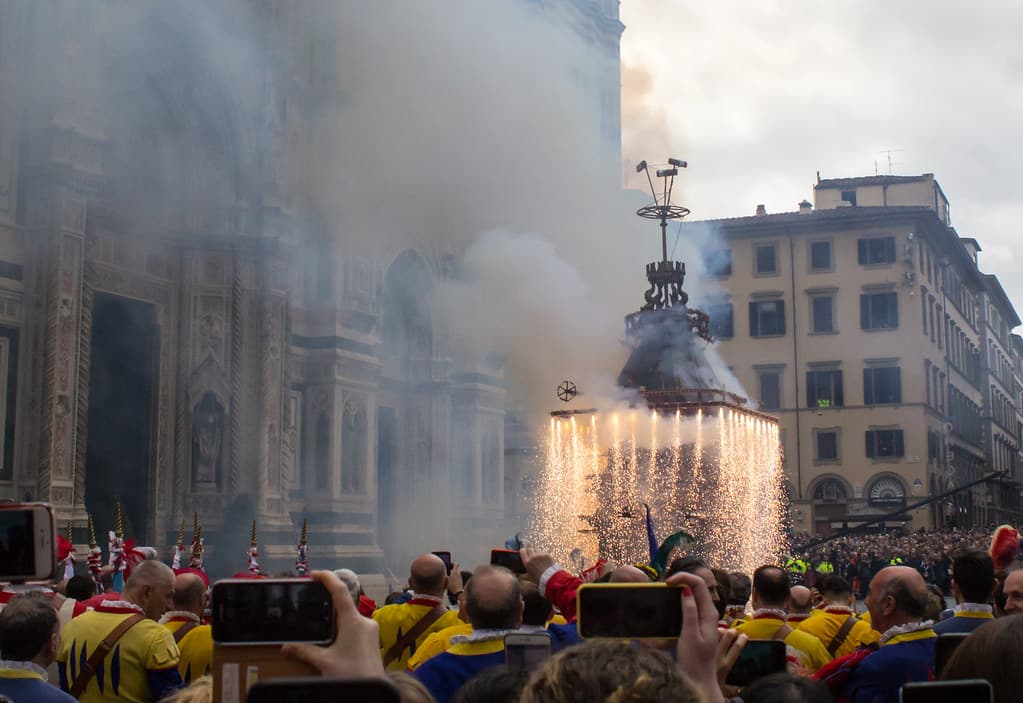 Clouds of smoke and sparks burst from the antique Brindellone cart in front of Florence cathedral as the crowd watches