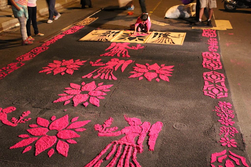 A red and white sawdust carpet laid out in the street for Semana Santa in Antigua Guatemala