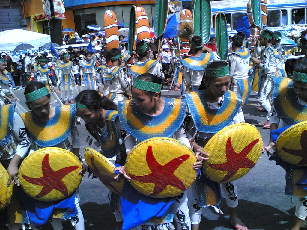 Dancers in blue costumes carrying painted shields at the Sinulog festival in Cebu