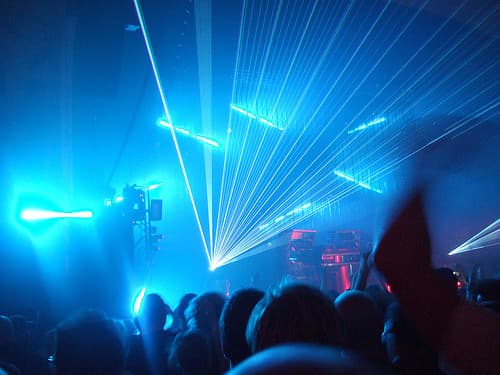 Laser beams fan out over a dancing crowd in a dark hall at Sónar in Barcelona