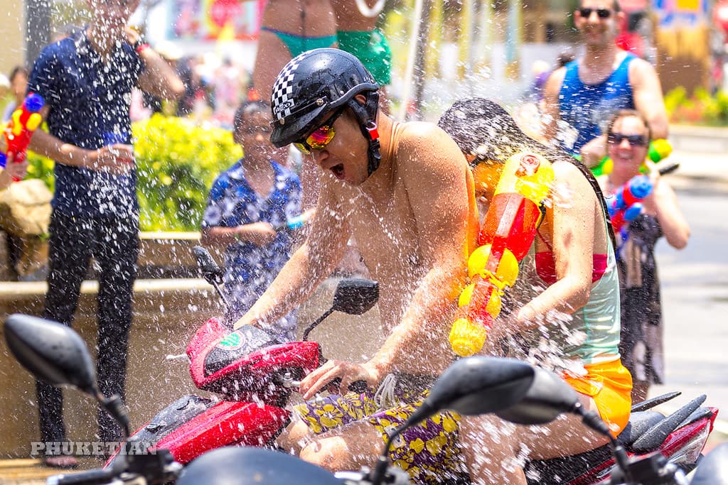 People soaked in water and laughing in the streets during Songkran