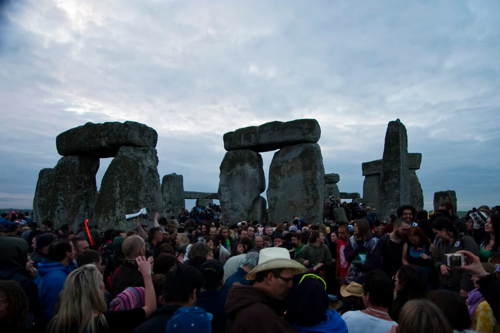 A large crowd gathers among the standing stones of Stonehenge on the morning of the summer solstice