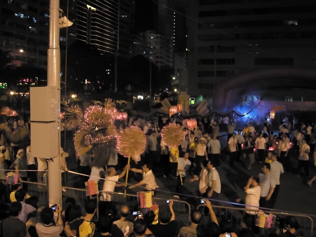 Performers carry the Tai Hang Fire Dragon, bristling with burning incense sticks, through a night crowd at a Hong Kong performance