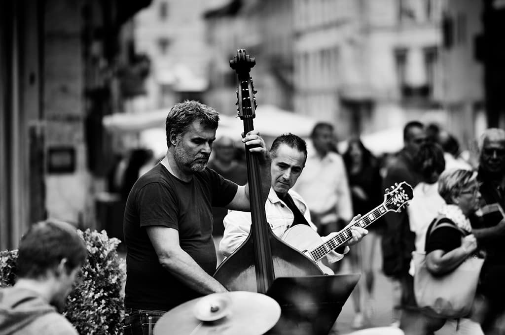 Street musicians play double bass and guitar among passers-by in Perugia during Umbria Jazz