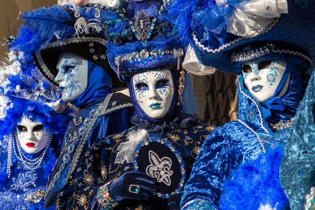 Costumed revelers in blue masks and tricorn hats at the Venice Carnival