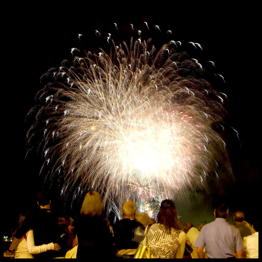 Fireworks burst in a golden shower over spectators at night during Bilbao's Aste Nagusia