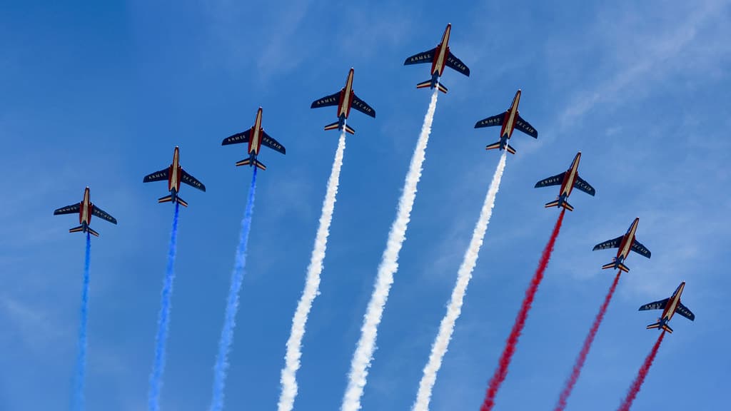 Nine jets of the French air force fly in formation over Paris trailing blue, white and red smoke on Bastille Day