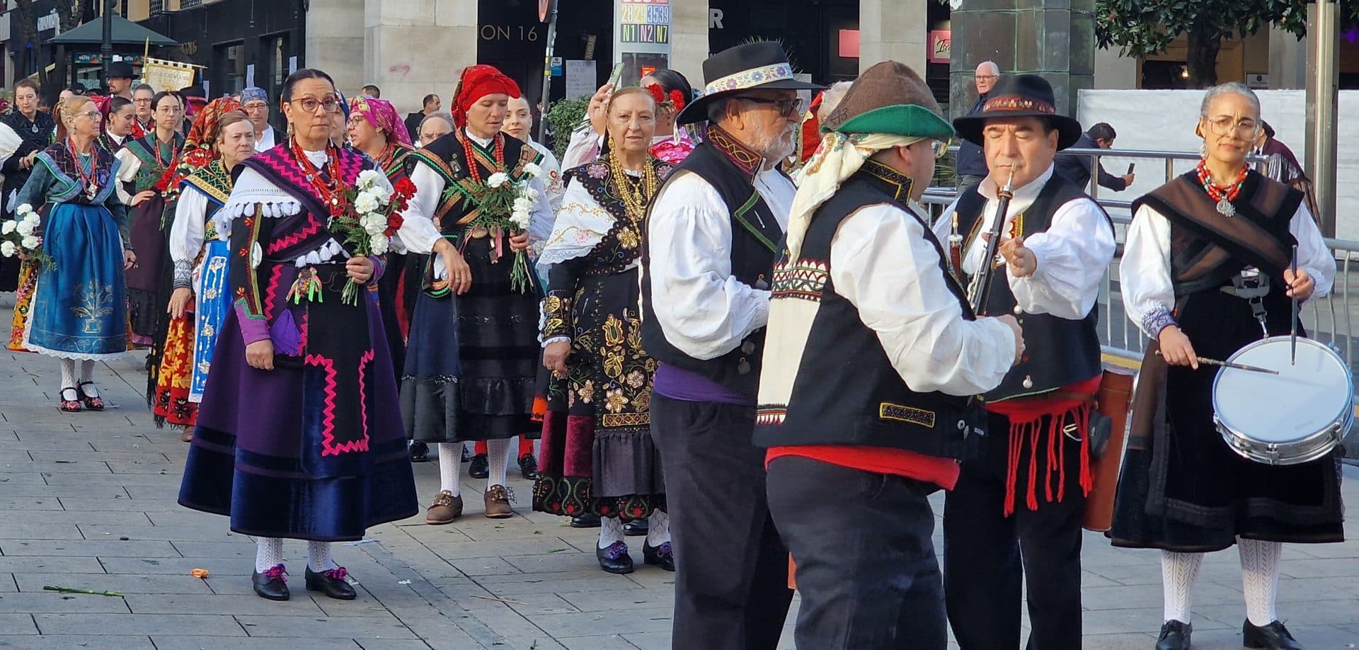 Marchers in traditional costume carry flowers through Zaragoza during the Ofrenda de Flores