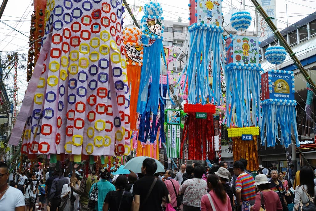 Colourful paper decorations and streamers hang over a crowded shopping street in Hiratsuka during the Tanabata festival