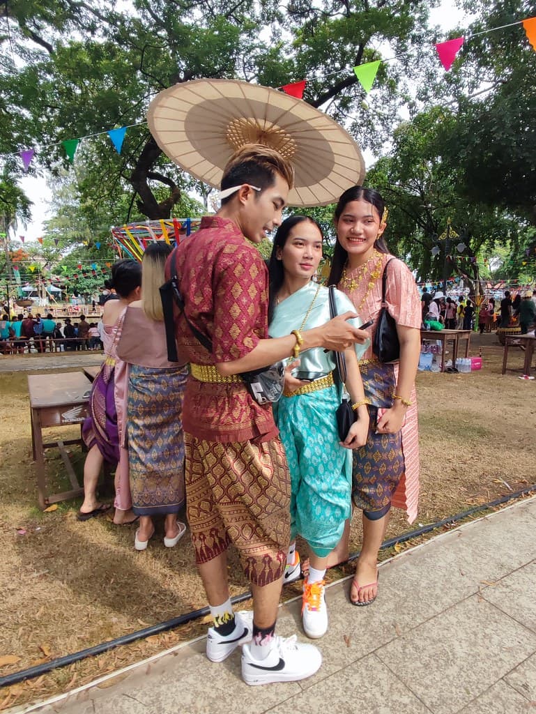 A couple in traditional Khmer dress pose under bunting at a Khmer New Year celebration in Siem Reap