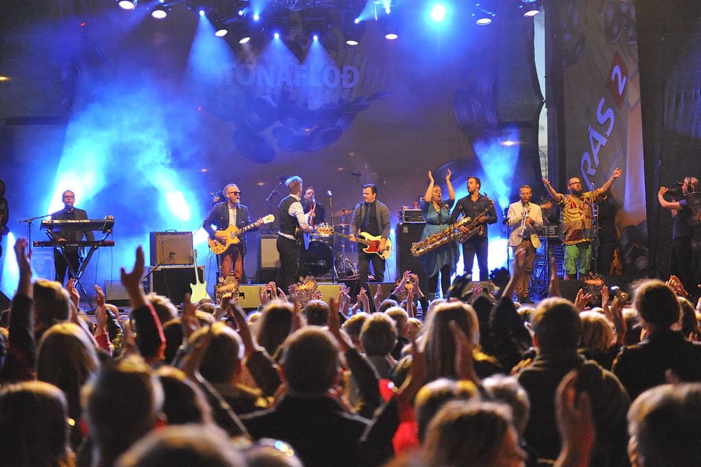 A band plays on a stage lit in blue before a crowd on Culture Night in Reykjavík