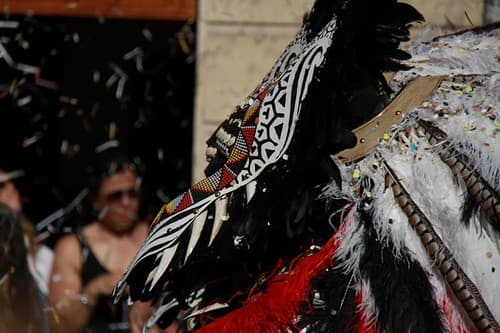 A festival participant in a black and white feathered costume during the parades in Alcoi
