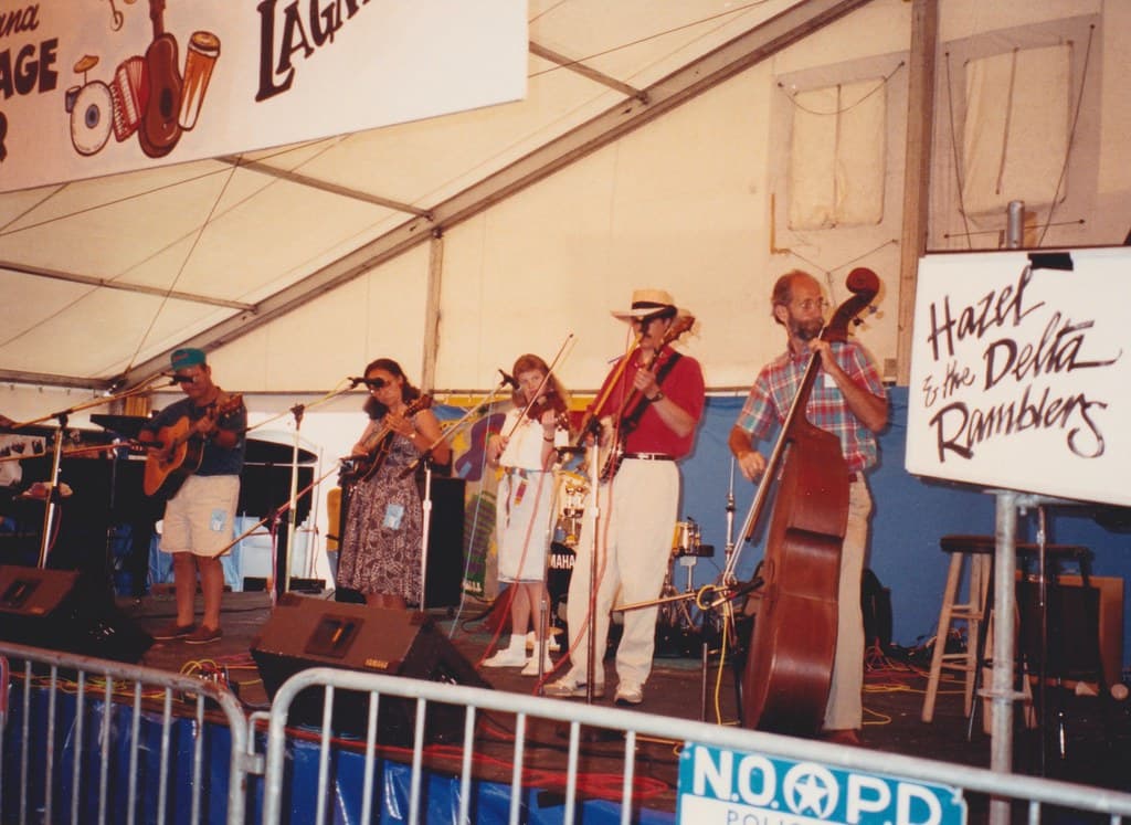 A string band plays under a festival tent on stage at the New Orleans Jazz and Heritage Festival