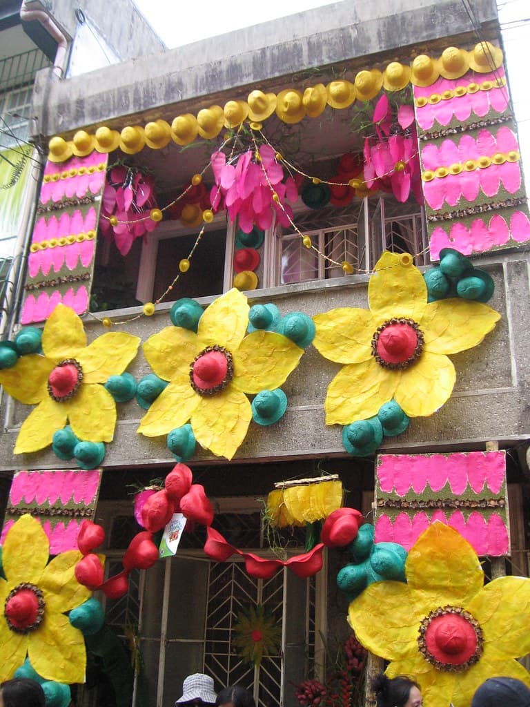 A house front in Lucban decorated with yellow and pink kiping flowers and rice wafers for Pahiyas