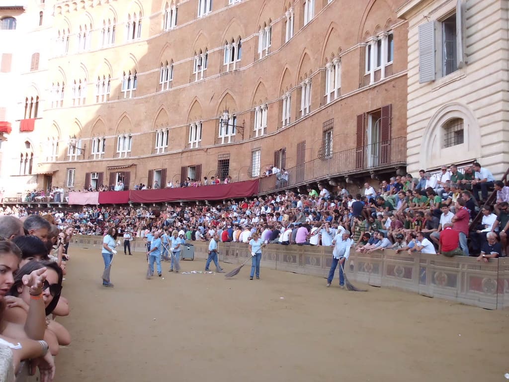Spectators pack the stands and balconies around the earth track laid in Siena's Piazza del Campo before a Palio run