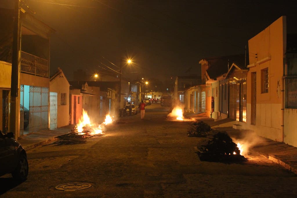 Bonfires burn in the middle of a quiet residential street at night in Campina Grande during São João