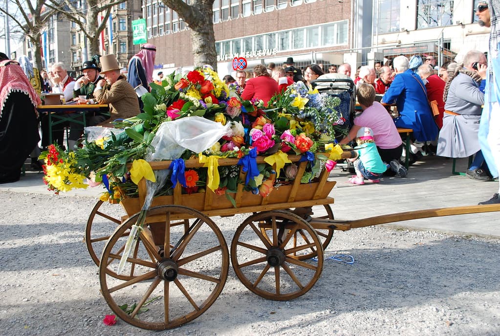 A wooden cart piled high with spring flowers is pulled through the crowd in the guild parade in Zurich