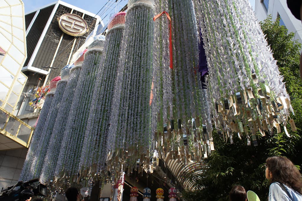 Long hanging columns made of thousands of strung paper decorations fill the roof of a Sendai shopping arcade