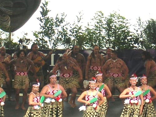 A kapa haka group of women in red and white bodices performs on the Te Matatini stage